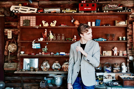 High school senior portrait depicting a young man in front of a variety of collectibles. Photo credit Bonni Allen.