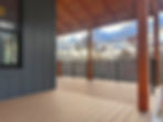Modern porch with stylish metal railings under a wooden canopy, offering a peaceful view of the surrounding landscape.