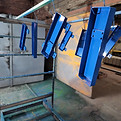 Blue powder painted metal parts of a scale hanging out of an industrial oven.jpg
