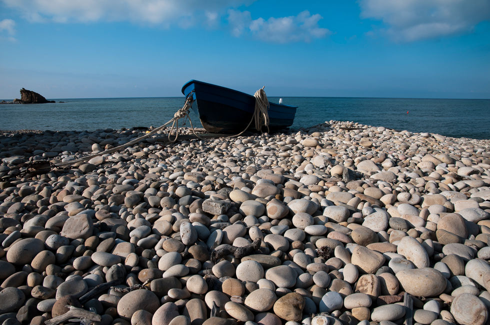 The boat on the white pebbles.