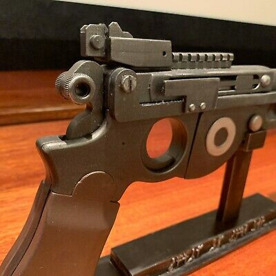 Close-up of a detailed metal pistol model on a stand
