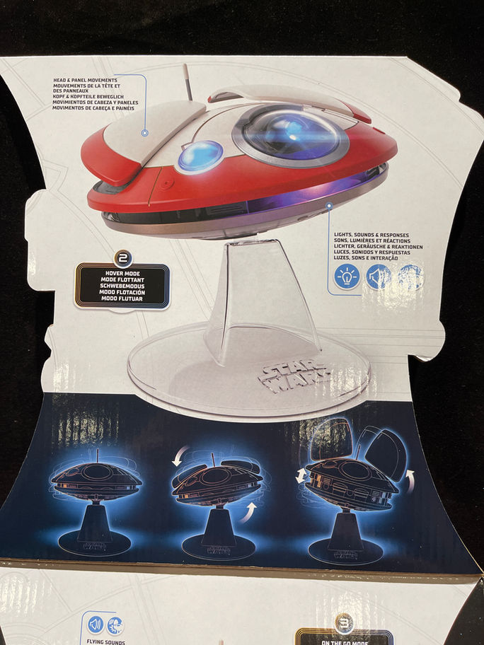 Red and white spaceship toy on display stand