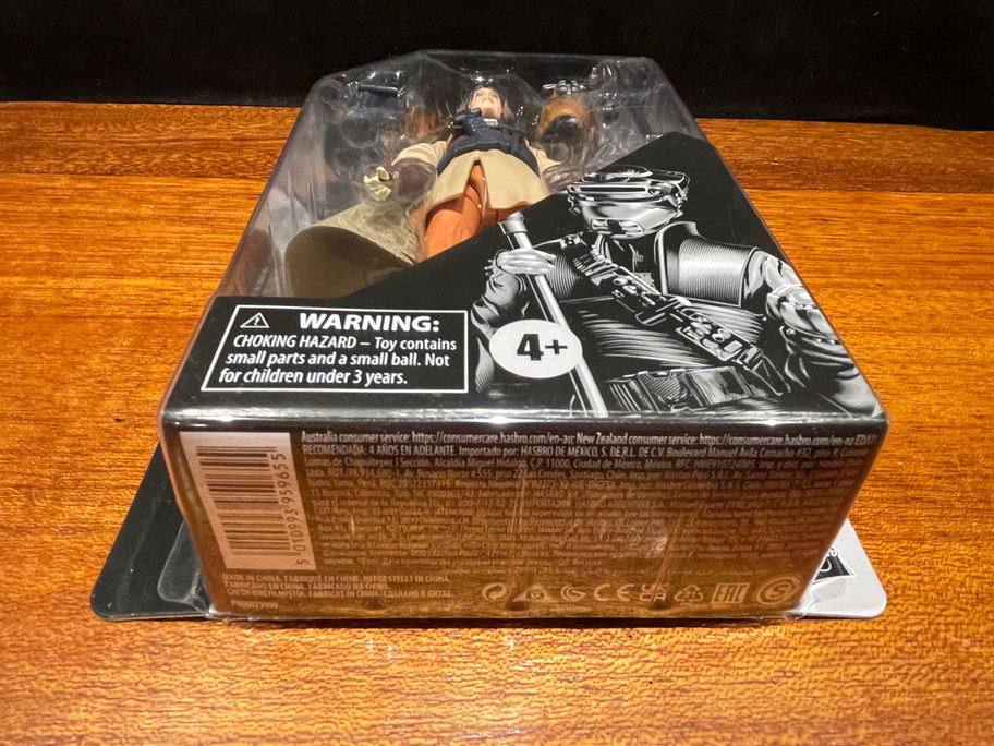 Action figure in box, warning label visible