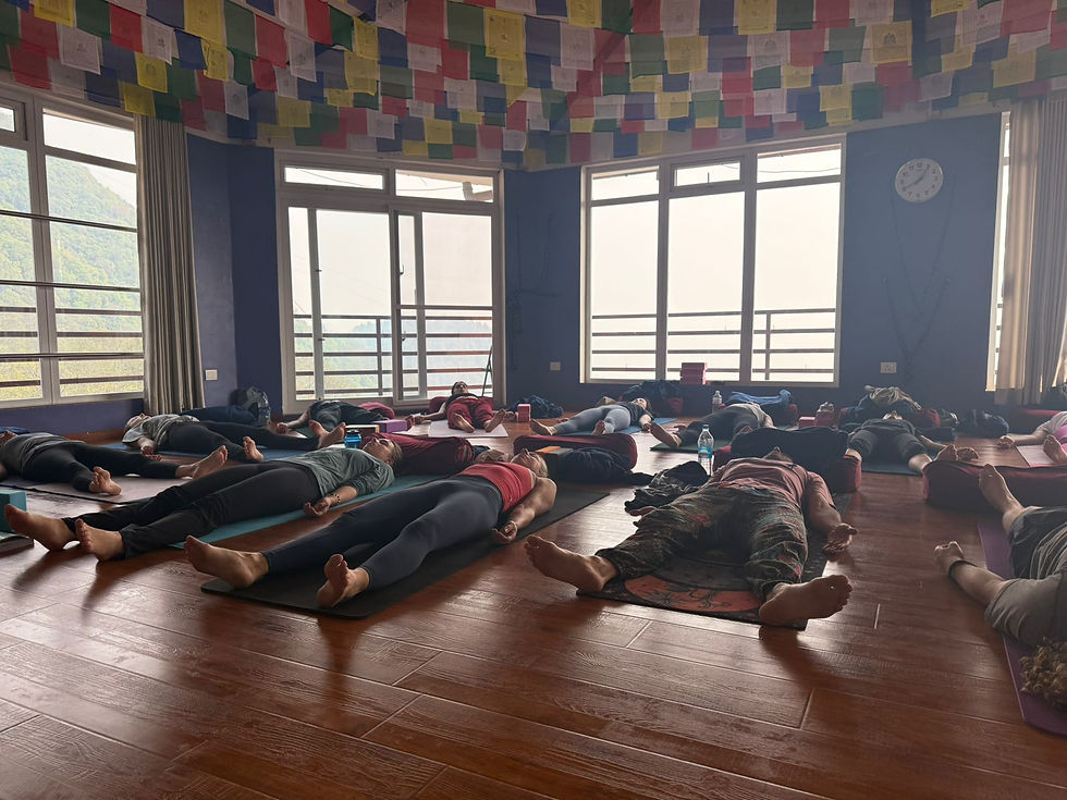 Wide angle view of yoga students practicing outdoors with Himalayan mountains in the background