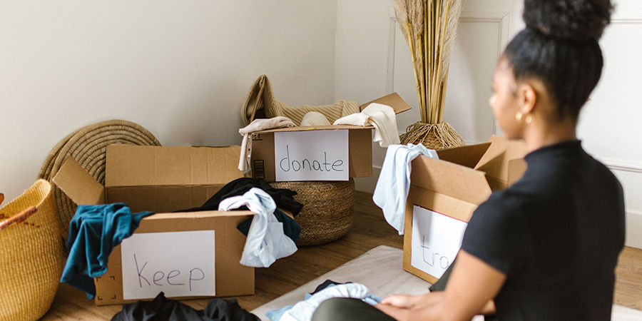 Mom attempting to sort piles for decluttering her home - Artkive decluttering tips