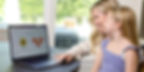 Mom and child reviewing their Artkive memory book proof together on a laptop before approving for print