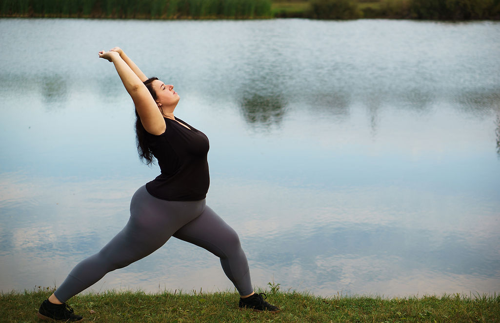 Women stretching outdoors by lake