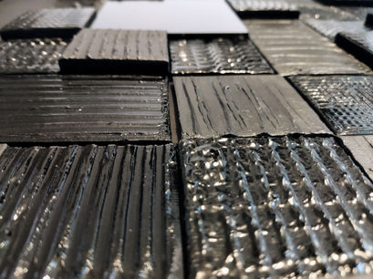 Iridum-Atlas- Véronique Bauquel, artiste plasticienne 3d, France. Collage sur bois enduit et peint à l'acrylique brillante, technique de collage de petites toiles travaillées comme la toile, avec des variantes de structures. Style patchwork noir mat, noir brillant.