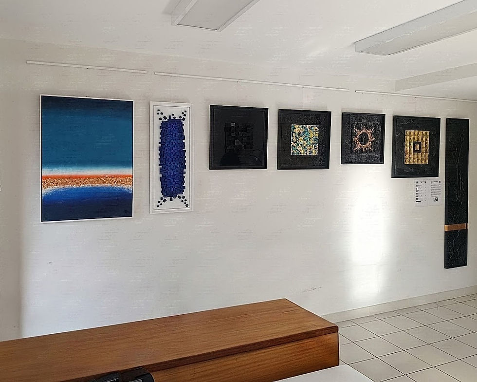 Scénographie épurée présentant une exposition de tableaux contemporains monochromes noirs et bleus accrochés dans une entrée élégante.