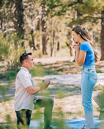 Man kneeling to propose to his partner during an intimate outdoor proposal