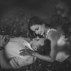 Black and white photograph of a couple resting together during an unposed engagement session