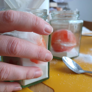 Salt is poured into a jar containing a tomato