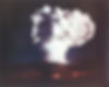 Mushroom cloud from a nuclear explosion against a dark sky. The cloud is large, white, and imposing, creating a dramatic scene.