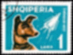 A stamp showing Laika, brown dog with rocket on blue background, in white; stamp features space theme.