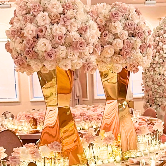 Elegant wedding centerpiece: blush roses in gold vases