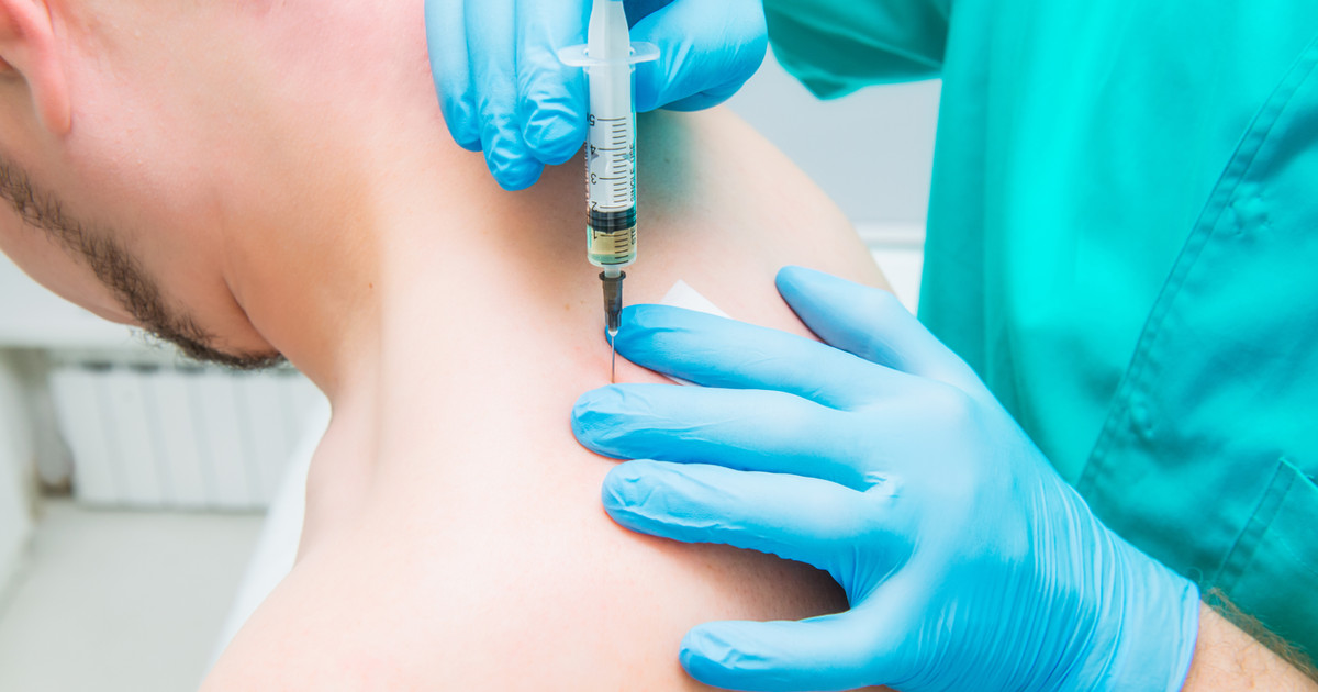 A clinician explaining a trigger point injection to a patient while identifying areas of muscle tension on the upper back.
