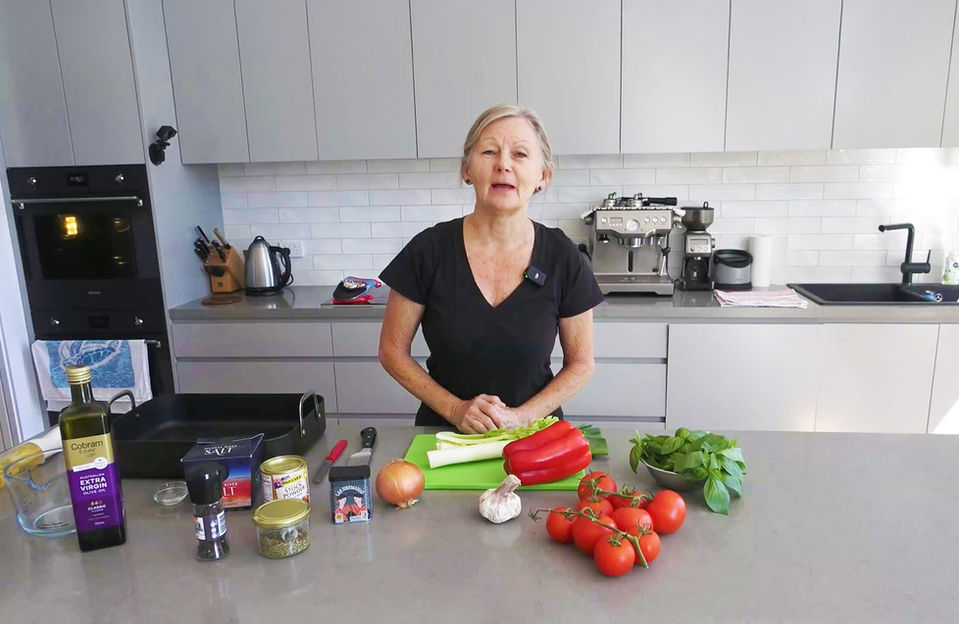 A mature lady teaching cooking in the kitchen