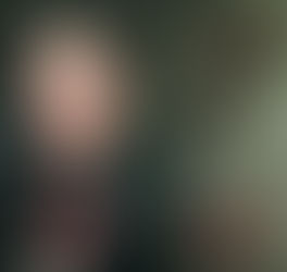 Young man in black leather jacket poses in front of graffiti featuring a cartoon figure holding a red dynamite stick. Dimly lit urban setting. RIOT SON - The Cage, a music blog powered by Cage Riot