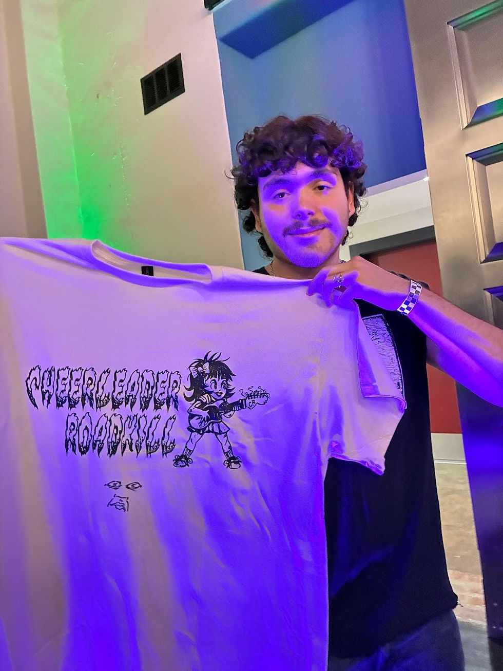 Fan of Cheerleader Roadkill Juan holding a signed t-shirt.