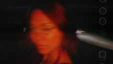 Blurred portrait of a person against a dark background with streaks of light, creating a disorienting effect. Red text on the right reads "vertigo." Lomi Mae - The Cage, a music blog powered by Cage Riot