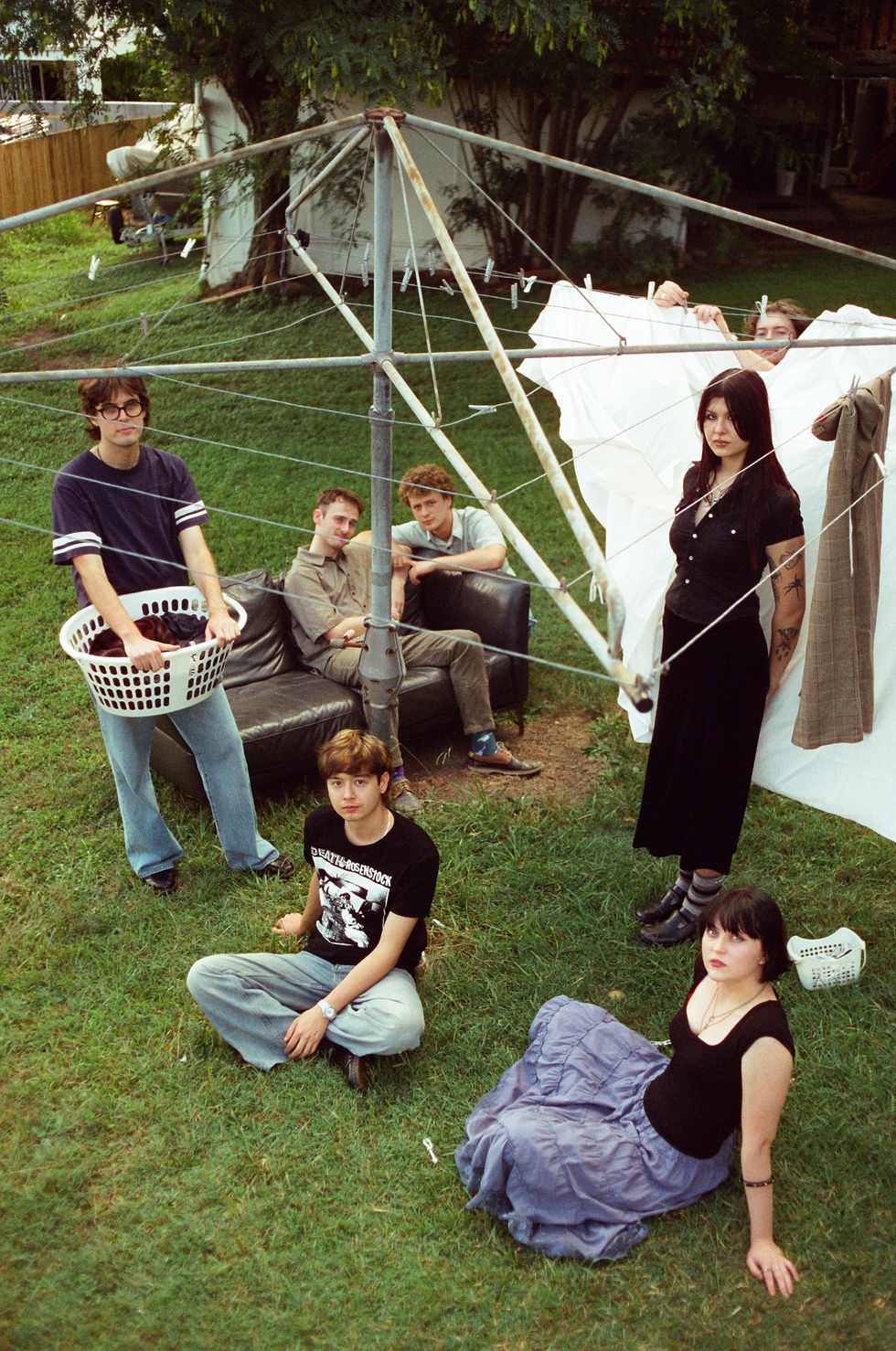 Young man in yellow and black shirt sits backward on a chair, looking pensive. Bright red background adds contrast and focus. Elliot James Reay- The Cage, a music blog by Cage Riot