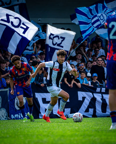 Spielszene: FCZ-Spieler im Laufduell mit Gegner bei Choreo im Stadion