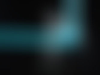 Blue PVC pipes with a leaking joint, splashing water against a black background. Water droplets are visibly spraying outward.