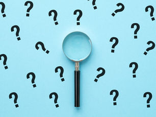 Magnifying glass centered on a blue background with scattered black question marks, suggesting curiosity and uncertainty.