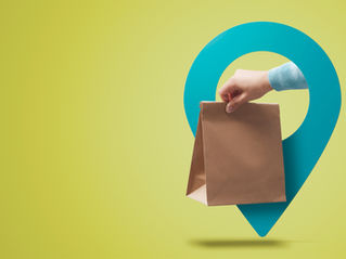 Hand holding a brown paper bag in front of a blue map pin icon on a lime green background. The scene suggests delivery or takeaway.