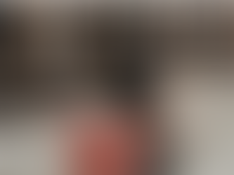 A forklift in motion blurs by shelves stacked with boxes in a warehouse. Floors are polished concrete. KUAF Ozarks at Large.