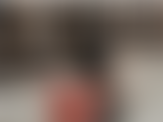 A forklift in motion blurs by shelves stacked with boxes in a warehouse. Floors are polished concrete. KUAF Ozarks at Large.