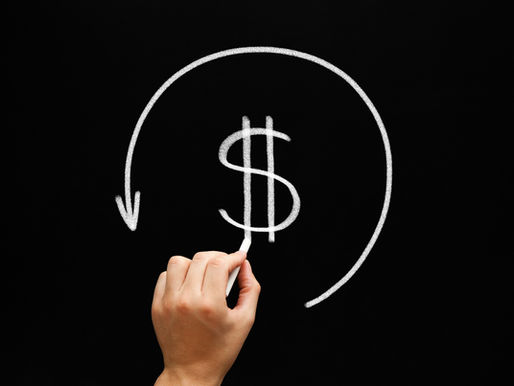 Hand drawing a dollar sign with a circular arrow in white chalk on a blackboard background.
