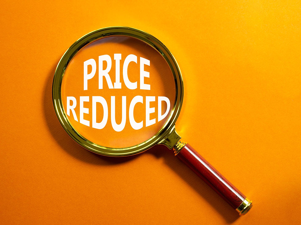 Magnifying glass over "PRICE REDUCED" text on an orange background, highlighting the words with a focused, promotional vibe.