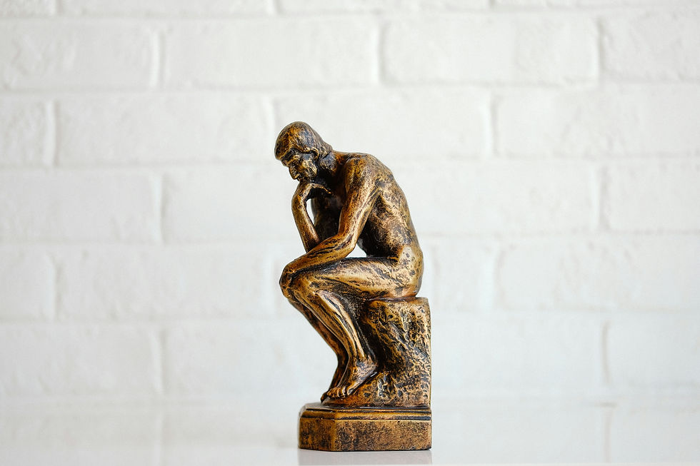 A bronze statue in the classic pose of the 'Thinker'