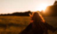 Chica corriendo en el campo al atardecer