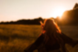 Girl Running in Field at Sunset