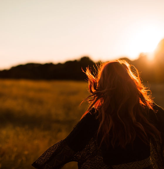 Girl Running in Field at Sunset