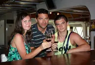 Три человека за столом в интерьере греческой таверны.