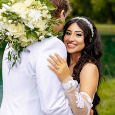 Groom embraces his bride during a sunlit outdoor portrait in the Wichita, KS area.