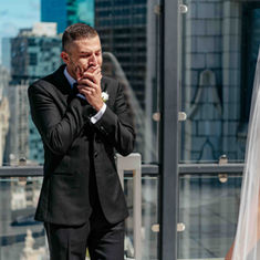 Groom covers his mouth in awe after seeing his bride for the first look.