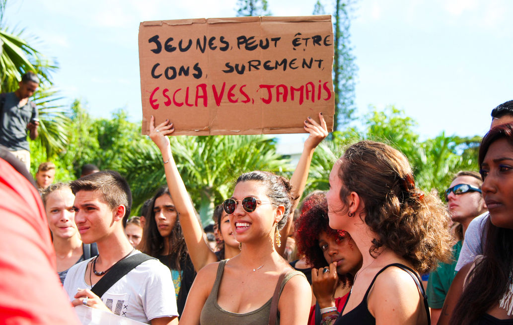 31 mars 2016, Saint-Pierre, La Réunion. Mi-février, le 17 exactement la ministre du Travail, Myriam El Khomri, dévoile dans la presse les grandes lignes de l'avant-projet de loi, présenté comme un moyen d'améliorer la compétitivité des entreprises et favoriser l’emploi. Cette réforme du Code du travail, dernière réforme sociale du quinquennat Hollande, connait un parcours tumultueux : 3 journées de mobilisation marquées par des violences, l'émergence de "Nuit debout" et les recours à l'article 49-3 pour la faire adopter sans vote au Parlement. Le 31 mars, partout en France métropolitaine et dans les territoires ultra-marins, comme ici à Saint-Pierre de La Réunion, la mobilisation atteint son apogée. Sur l’ensemble du territoire national, La Réunion compris, la manifestation réunit entre 1,2 million (syndicats) et 390 000 personnes (police) dans les rues. La Réunion, Saint-Pierre, Le JIR - Le Journal de l'ile de La Réunion - Edition 1er avril 2016 - « Manifestation contre la loi El Khomri, Le Sud tient ses promesses» - © Véronique Tournier - manifestation mairie