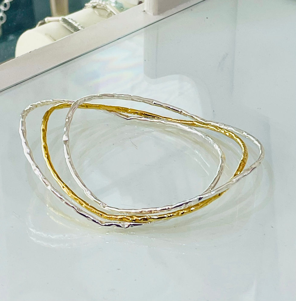Thumbnail: handmade, hammered set. sterling silver and gold wavy bangles. textured, liquid finish. Eye-catcher, statement piece.