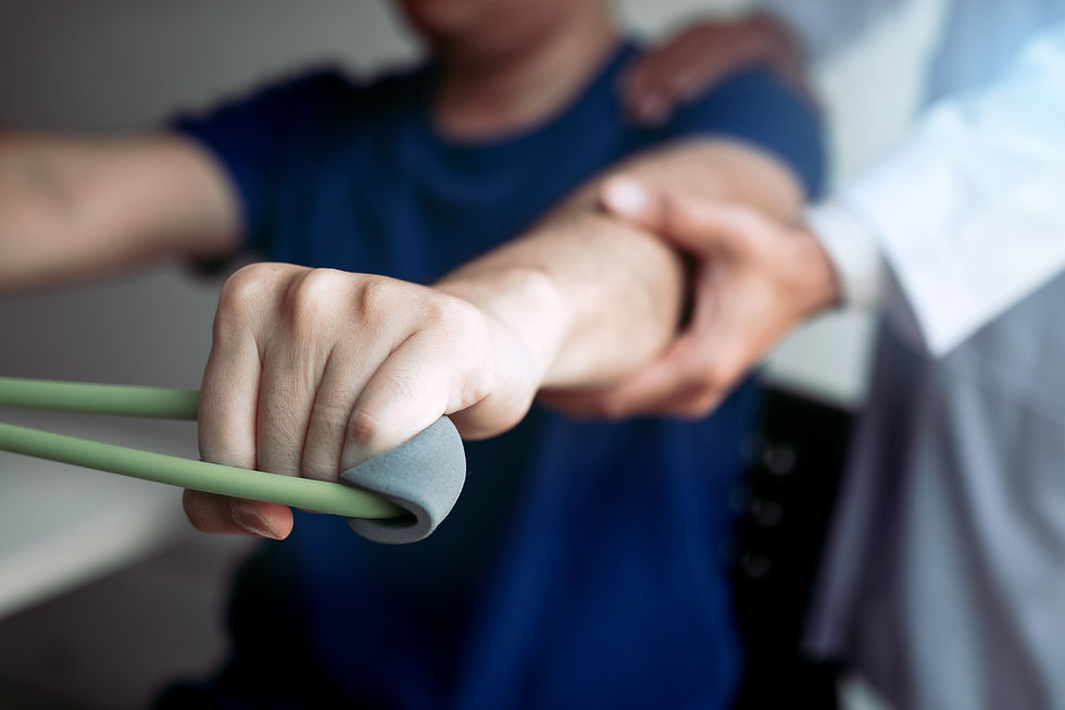 A physiotherapist guiding a male patient through a resistance band exercise for shoulder and arm rehabilitation during a combined physiotherapy session.