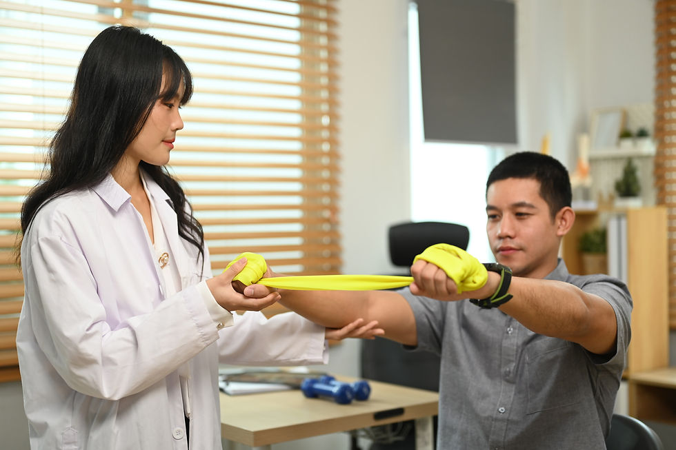 Woman in a lab coat assists a man exercising with a yellow resistance band in a bright room with wooden blinds and plants.