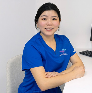 Low Shi Chia, a nurse at Straits Geriatrics Centre, seated at her desk in a modern and professional setting.