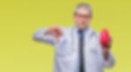 Doctor in white coat gives thumbs down, holding red heart model. Yellow background, serious expression. Stethoscope around neck.
