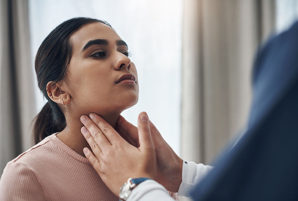 A woman in a pink shirt undergoing a neck examination by a doctor. The background is softly blurred, and the mood is calm.