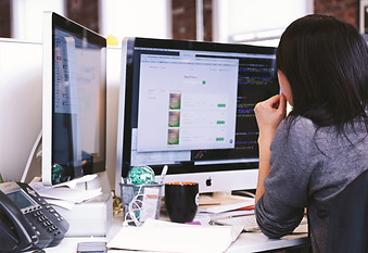 Woman reviewing website design on computer
