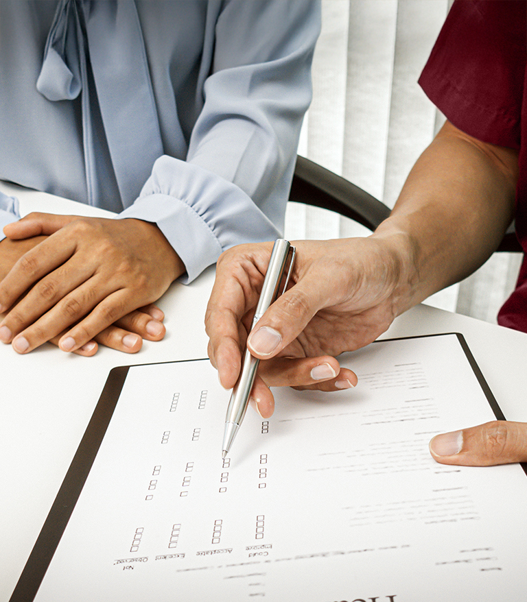 Doctor reviewing a form with a patient during an acne consultation at The Acne Clinic in i12 Katong Singapore.