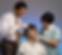 Medical professionals adjust a head brace on a patient in a clinical setting. The patient wears a hospital gown. The background is blue.
